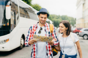 Zwei Reisende vor einem Bus mit Karte